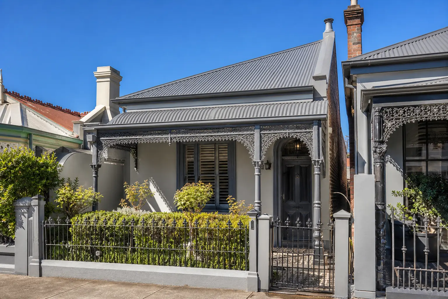 Illustration: Victorian terrace with a grey corrugated metal roof and iron lace verandah