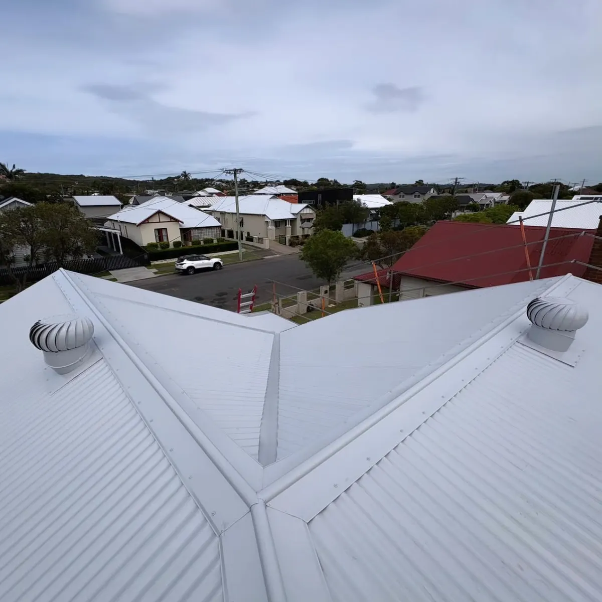 New white corrugated metal roof with valleys and whirlybirds, looking over a Newcastle street